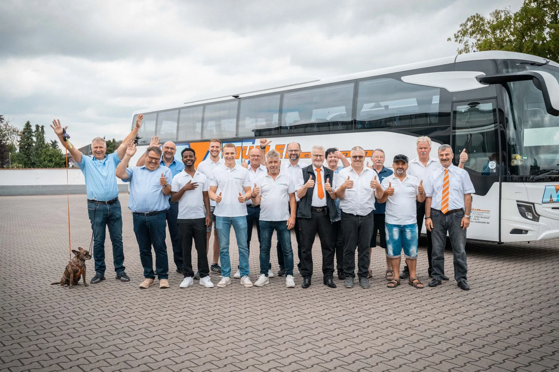 Winkende Reisegruppe vor dem Müller-Reisebus