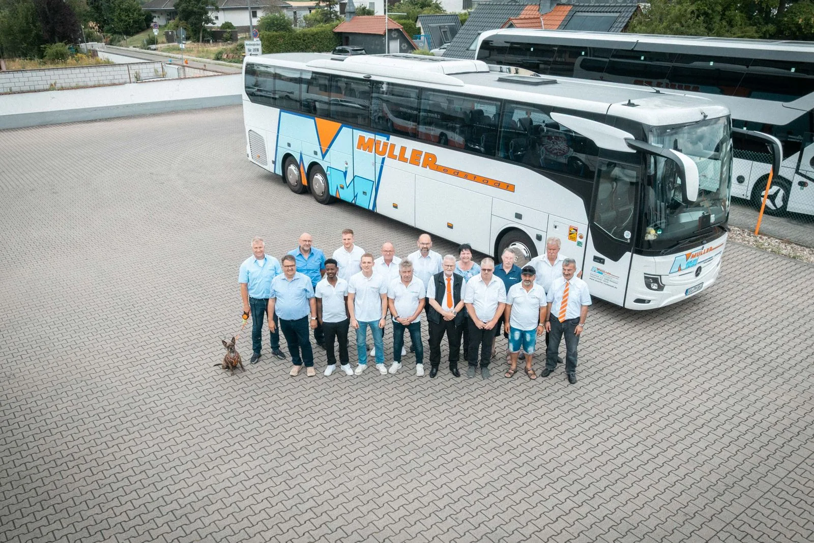 Mitarbeiterinnen und Mitarbeiter vor einem Reisebus auf dem Betriebshof