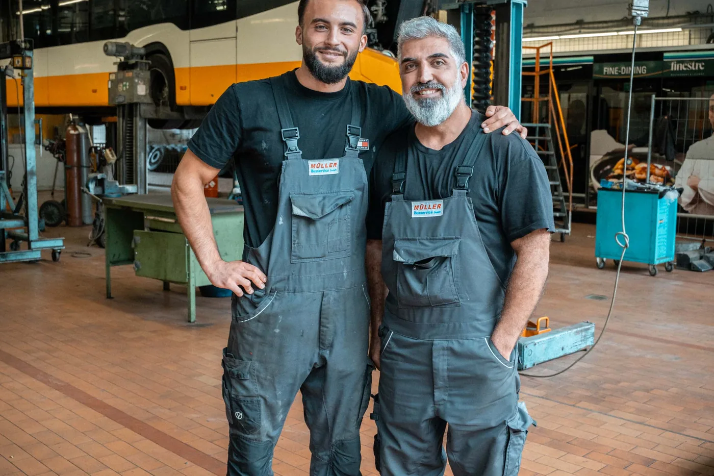 Zwei Mechaniker in der Werkstatthalle